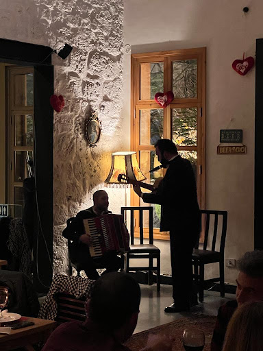A guitarist and an accordion player performing at an evening gathering