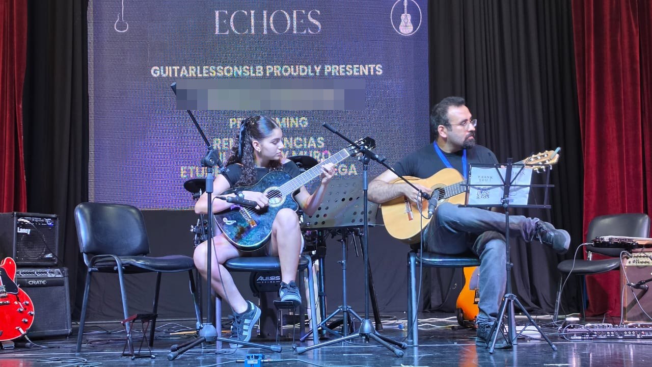 A student and her teacher playing guitars together on the Echoes stage