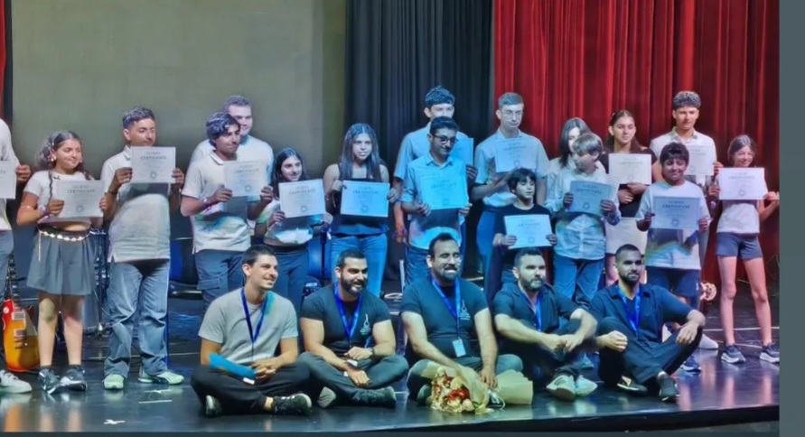 Students and teachers on stage holding certificates after Echoes