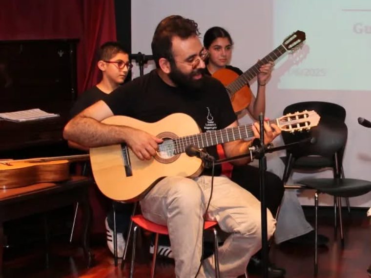 Elias accompanying students on stage at the annual student concert